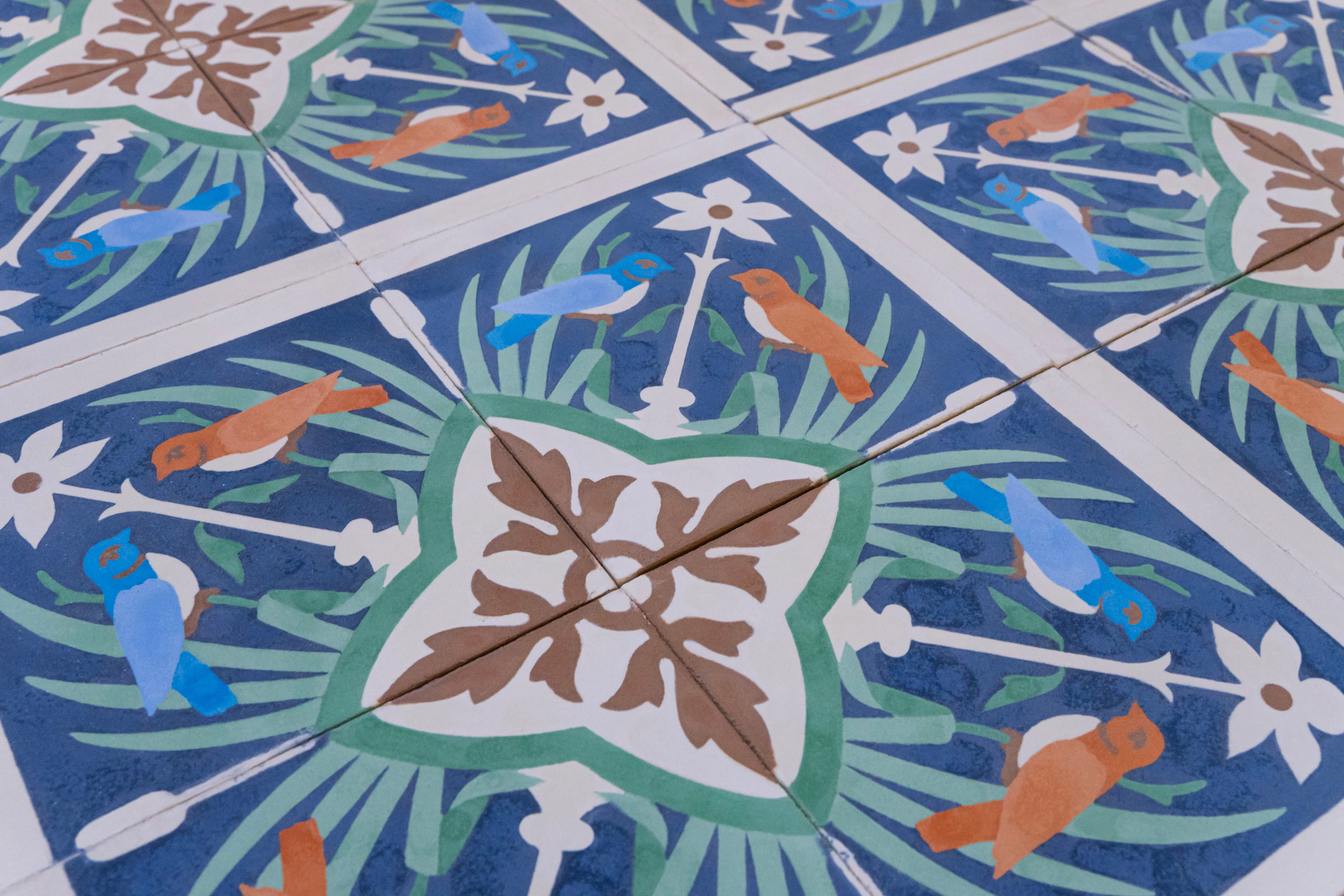 Composição de ladrilhos azuis com pássaros, folhas e flores