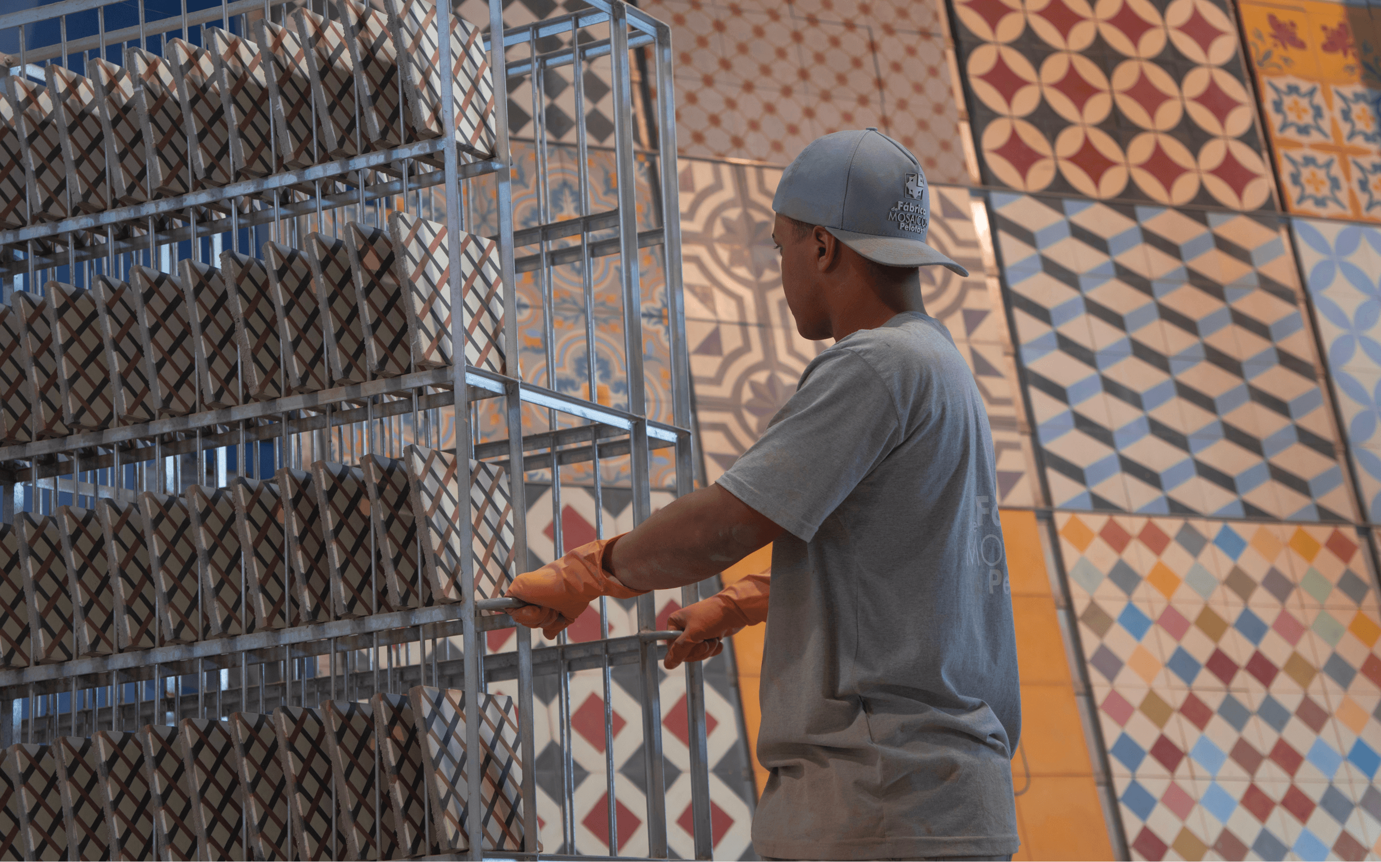 Artesão trabalhando diante do acervo de moldes da Fábrica de Mosaicos