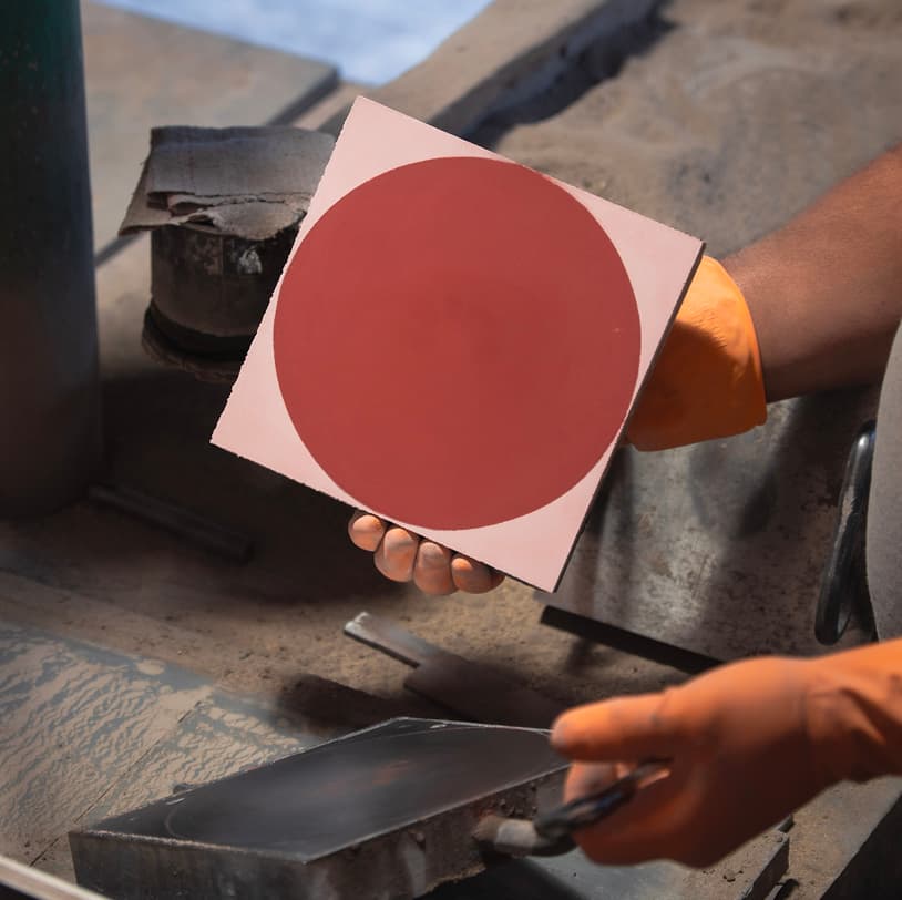 Artesão segurando ladrilho com círculo vermelho