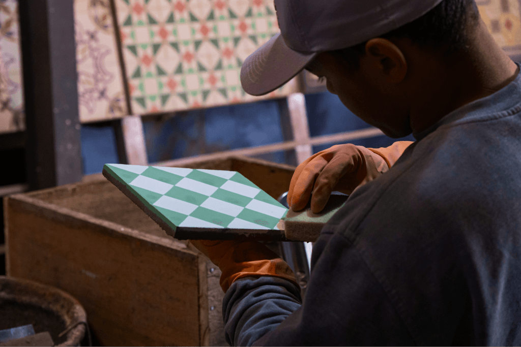 Artesão fazendo o acabamento de um ladrilho