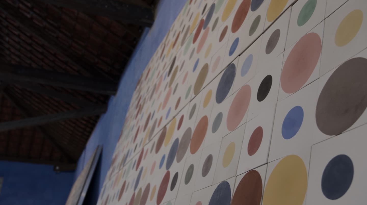 Parede da fábrica revestida com ladrilhos de círculos coloridos